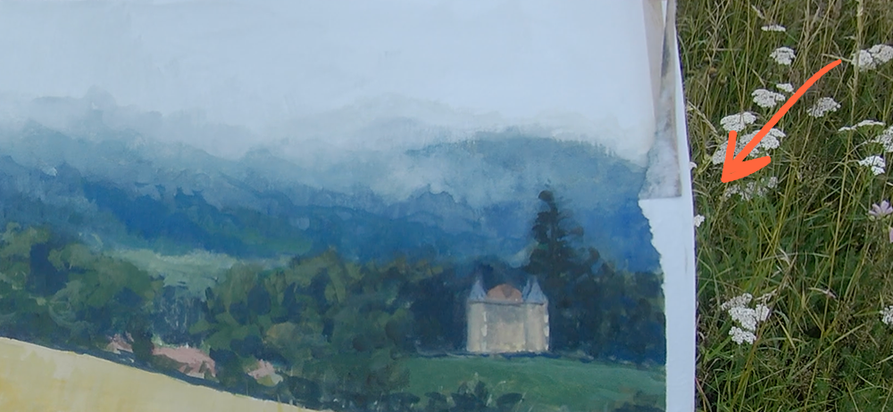Bord de gouache en plein air où l’adhésif commence à arracher un papier encore humide par temps pluvieux