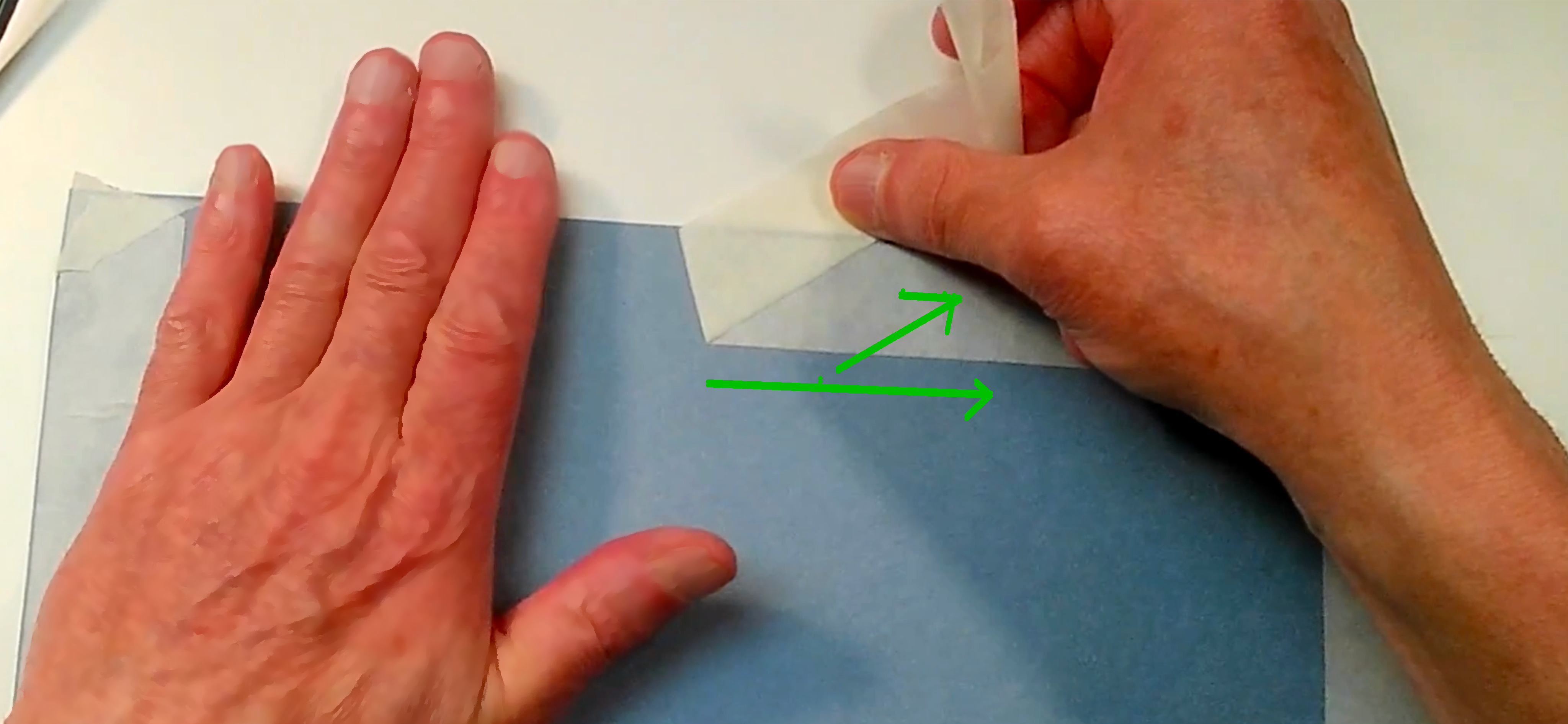 Retirer l’adhésif sans déchirer le papier Deux mains retirant un ruban adhésif à faible angle pour éviter de déchirer le papier